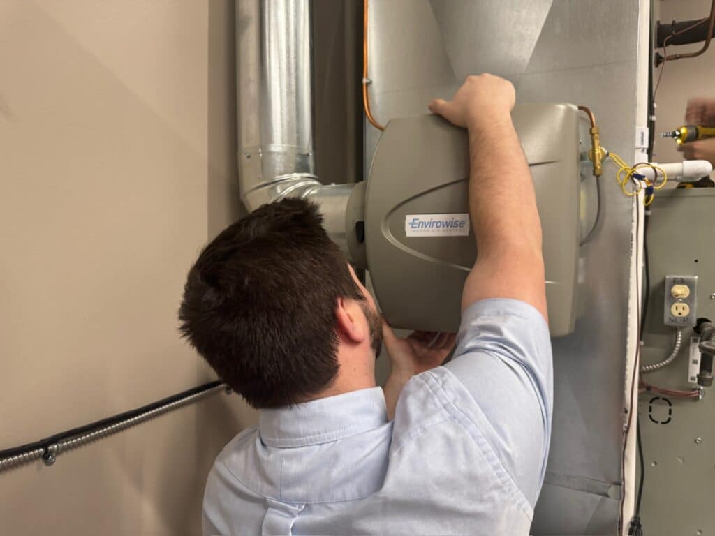 Watkins Employee Does Maintenance on HVAC System